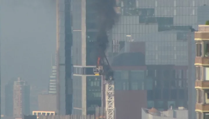 New York construction crane catches fire, and its arm hits skyscraper as it crashes to street